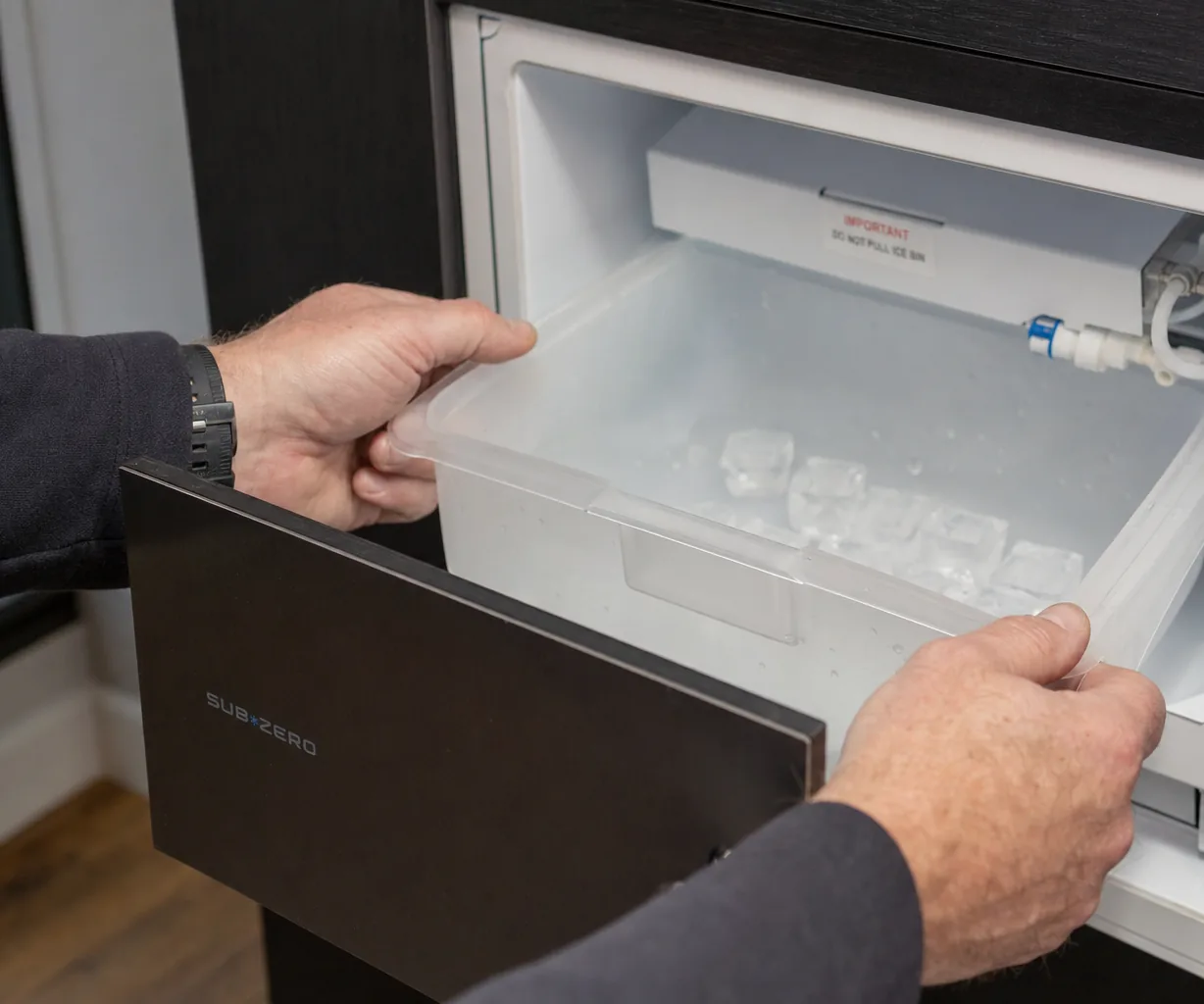 Technician servicing a built-in ice maker in a Harrison kitchen